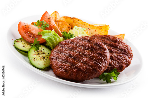Foto: Grilled beefsteaks, baked potatoes and vegetable salad Grilled beefsteaks, baked potatoes and vegetable salad