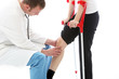 Photo: Orthopaedic surgeon sitting examining the knee of a patient Orthopaedic surgeon sitting examining the knee of a patient