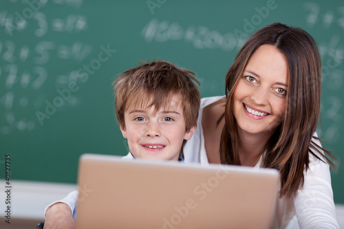 Photo: lehrerin und schulkind arbeiten am laptop lehrerin und schulkind arbeiten am laptop