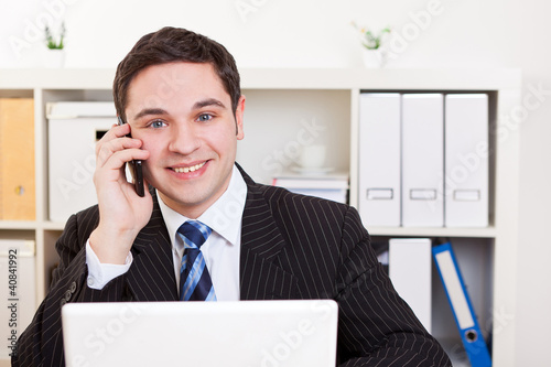 Photo: Geschäftsmann im Büro mit Handy Geschäftsmann im Büro mit Handy