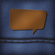 Blank leather jeans label in speech bubble shape on a blue jeans