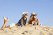 girls laying in sand on summer vacation