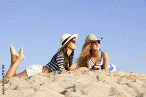 Photo: girls laying in sand on summer vacation girls laying in sand on summer vacation