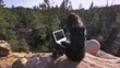 Girl with laptop in natural park, mountain