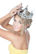 Smiling young blonde girl with silver crown over white