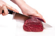 Zwei Hände schneiden ein Stück Rindfleisch