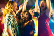 Party people dancing in disco or club