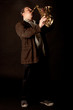 Jazzman standing playing saxophone on a dark background, low key