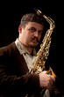 Musician holding tight saxophone in hands, close-up
