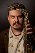 Foto: Musician holding saxophone in front of his face, close-up Musician holding saxophone in front of his face, close-up
