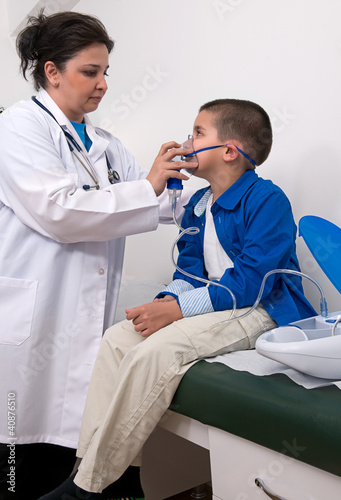 Photo: Female doctor applying oxygen treatment on asthma child. Female doctor applying oxygen treatment on asthma child.