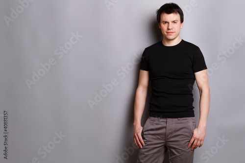 Photo: junger mann vor grauen hintergrund junger mann vor grauen hintergrund