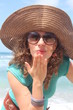 Young woman sending a kiss, at the beach