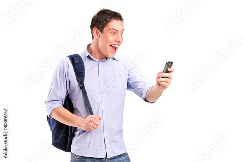 Photo: A portrait of a smiling young man looking at a cell phone A portrait of a smiling young man looking at a cell phone