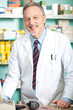 Mature chemist in his store