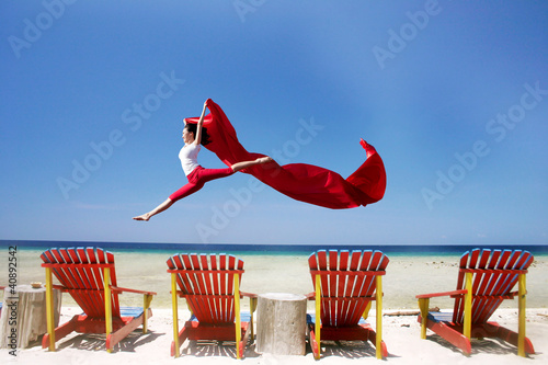 Photo: Carefree woman jumping at beach Carefree woman jumping at beach