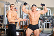 Two bodybuilders posing at the gym