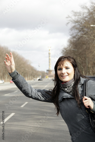 Photo: junge Frau winkt nach einem Taxi junge Frau winkt nach einem Taxi