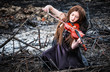 The red-haired girl with a violin sitting on the ashes
