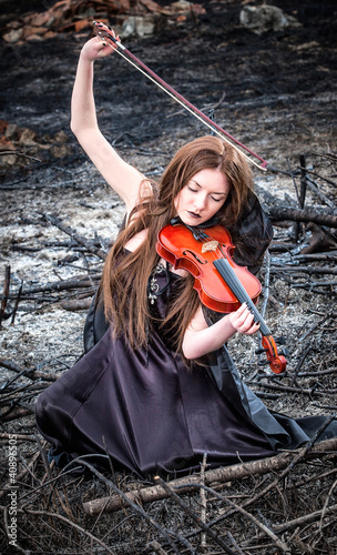 Photo: The red-haired girl with a violin sitting on the ashes The red-haired girl with a violin sitting on the ashes