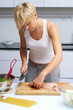 pretty blond girl in the kitchen making pasta