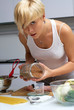 pretty blond girl in the kitchen making pasta