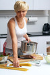 pretty blond girl in the kitchen making pasta