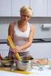 pretty blond girl in the kitchen making pasta