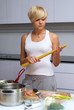 pretty blond girl in the kitchen making pasta