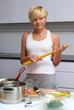 pretty blond girl in the kitchen making pasta