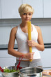 pretty blond girl in the kitchen making pasta