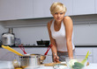 pretty blond girl in the kitchen making pasta