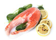 Red fish with lemon, green leaves and pepper isolated on white.