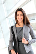 Smiling businesswoman in hall with briefcase