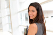 Young businesswoman in modern building holding files