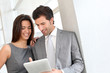 Business partners working in hall on electronic tablet