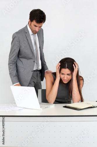 Foto: Businessman in office harassing young woman Businessman in office harassing young woman