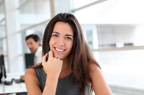 Photo: Young woman working in office Young woman working in office