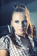 Beautiful blond model sitting on old car at night shot