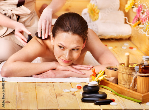 Photo: Woman getting stone therapy massage . Woman getting stone therapy massage .