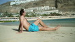 Young man sitting on the beach