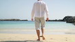 Young man walking on the beach