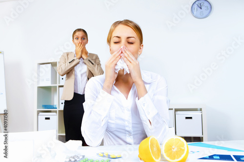Photo: People with cold and flu at work place People with cold and flu at work place
