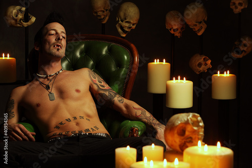 Photo: Male vampire sitting on leather chair Male vampire sitting on leather chair