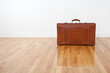 Retro leather suitcase on wooden floor Retro leather suitcase on wooden floor
