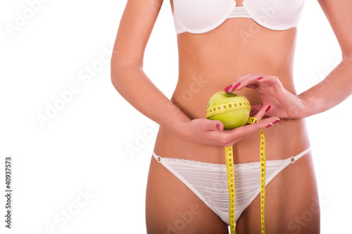 Photo: Young woman measuring her waist, isolated on white background Young woman measuring her waist, isolated on white background
