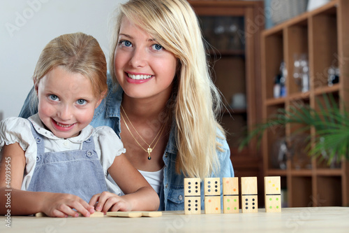 Foto: Mother and daughter playing dominoes Mother and daughter playing dominoes