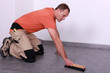 A man laying lino.
