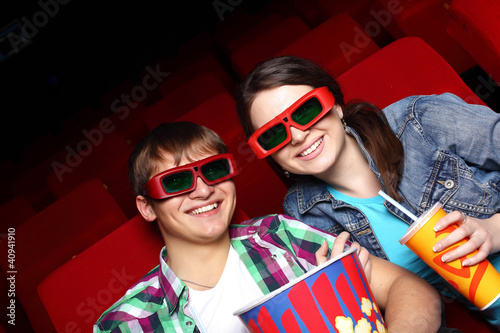 Photo: Young couple in cinema watching movie Young couple in cinema watching movie