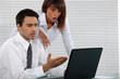 Shocked business couple in front of laptop